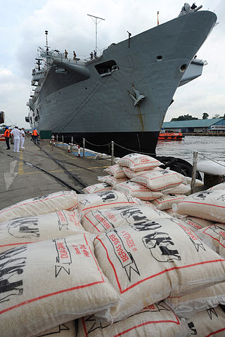 HMS Illustrious loading supplies in Singapore. Source: Wikimedia Commons/MoD
