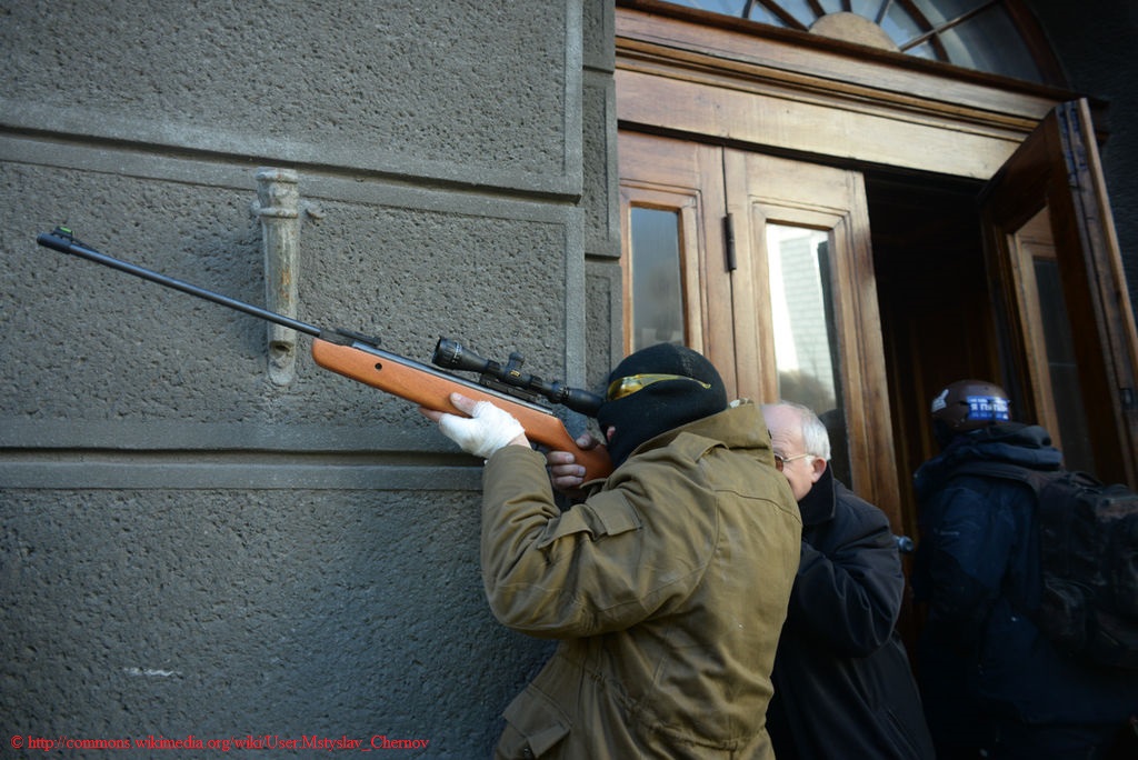 Ukrainian protestor aims a rifle during clashes in Kiev in February 2014.