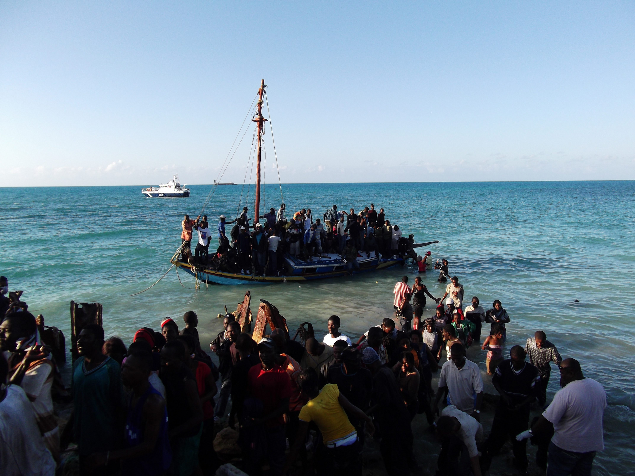 Residents of the Turks and Caicos Islands in the Caribbean assist passengers on an overcrowded sloop. The boat had just arrived from Haiti carrying 139 people. UNHCR / 25 February 2011